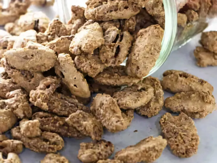 A jar on its side spilling out candied pecans on the counter.