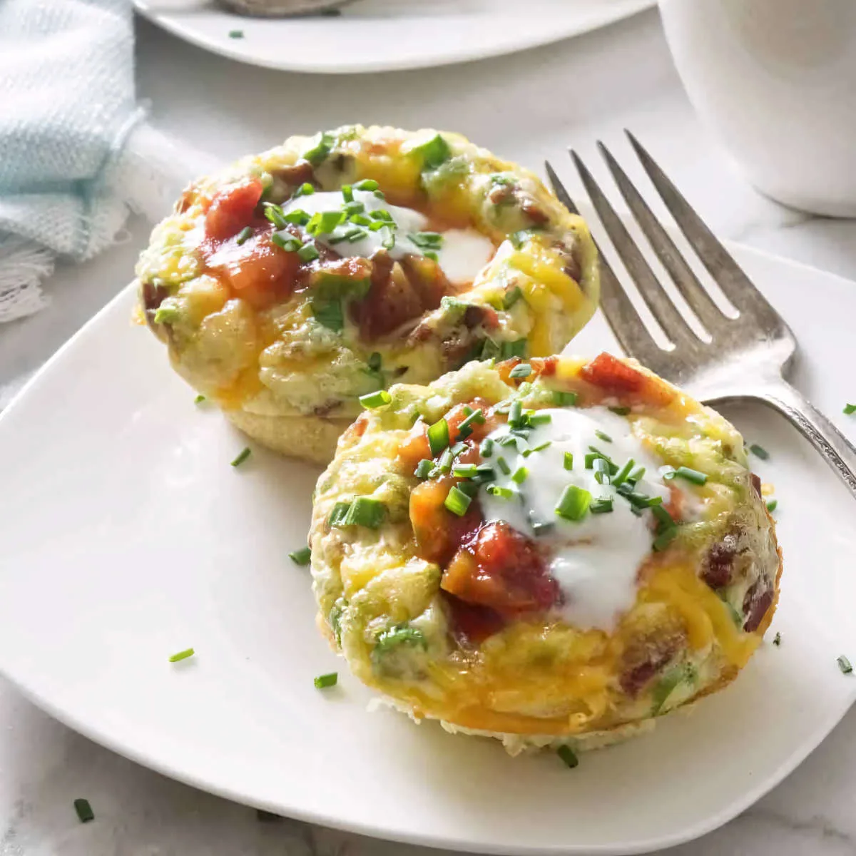 Turkey bacon egg muffin cups on a plate with a fork.