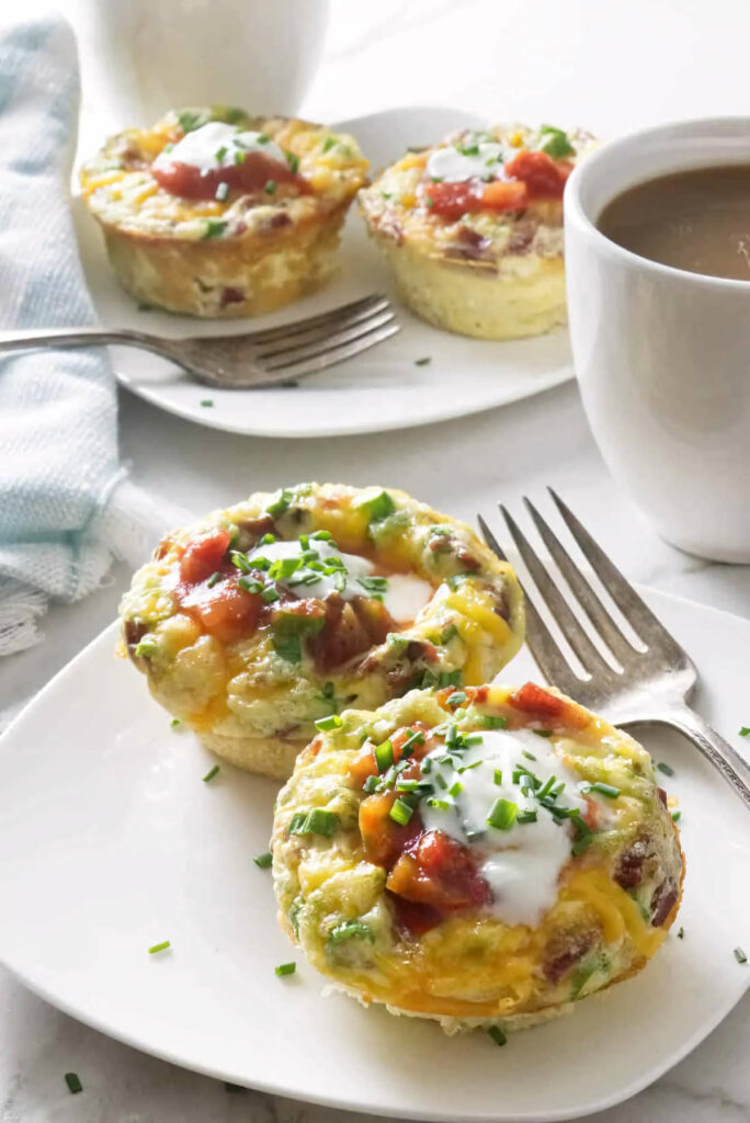 Several egg muffins with turkey bacon next to a cup of coffee.