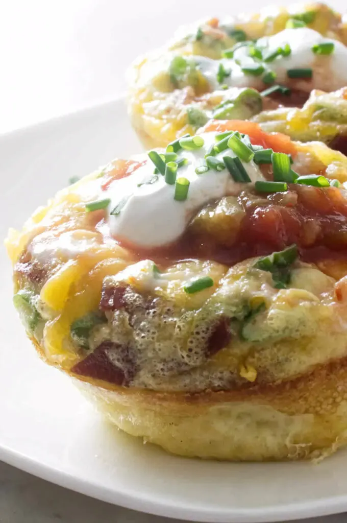 Egg muffins on a plate and topped with salsa.