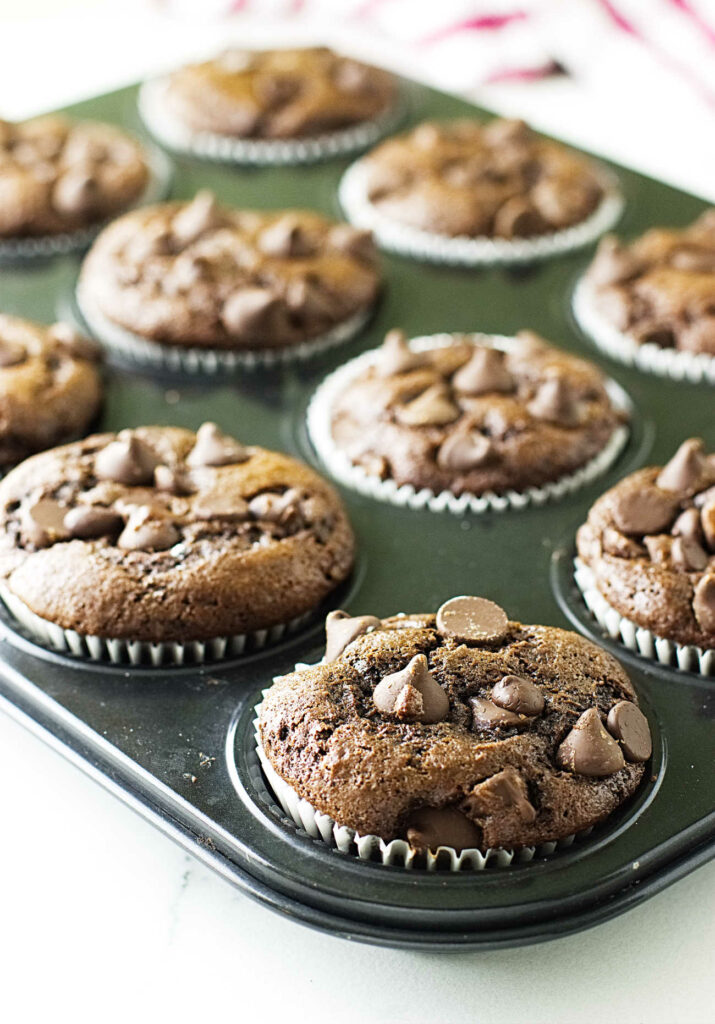 Chocolate einkorn muffins cooling in a muffin tin.