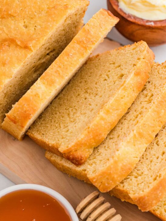 A loaf of einkorn sandwich bread sliced into 1/2 inch thick slices.