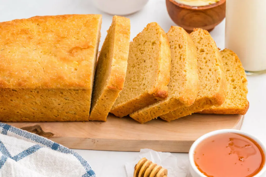 A loaf of einkorn flour bread next to a dish of honey.