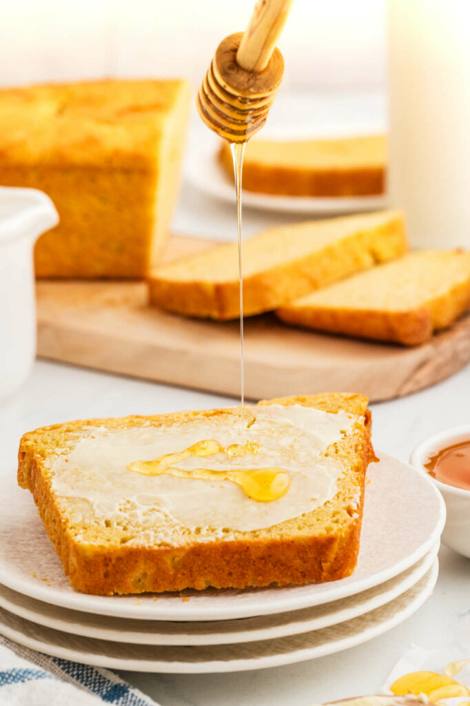 Drizzling honey on a slice of all purpose einkorn flour bread.