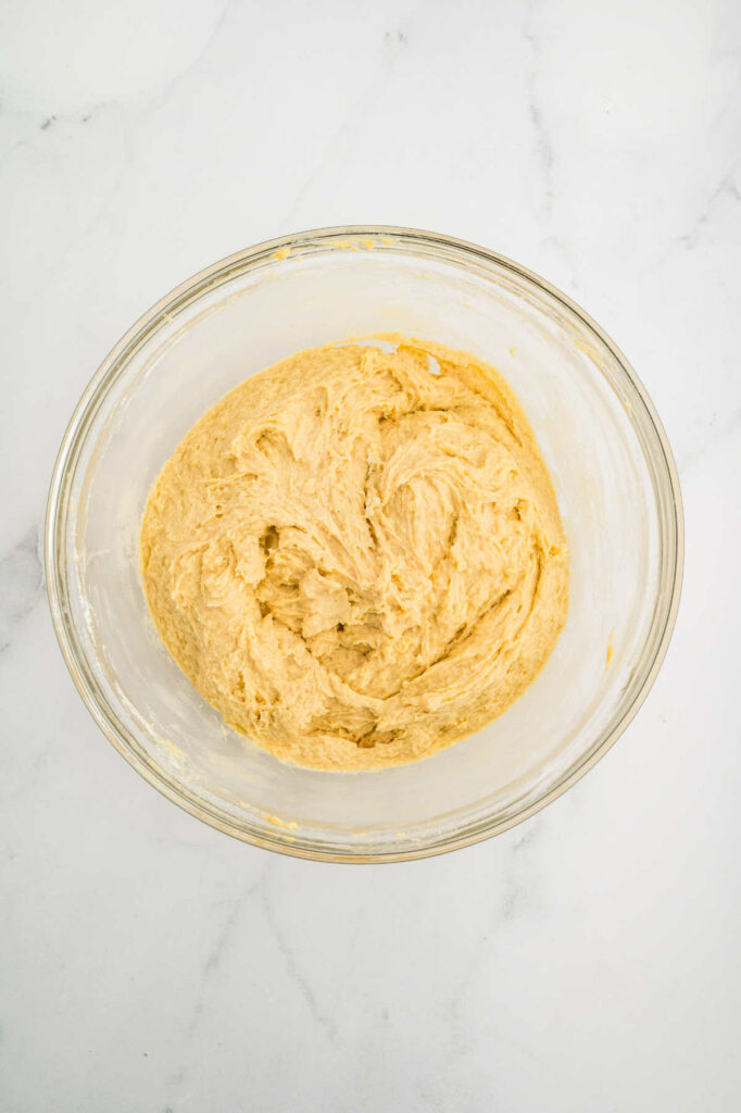 Mixing dough in a bowl to make an einkorn bread recipe.