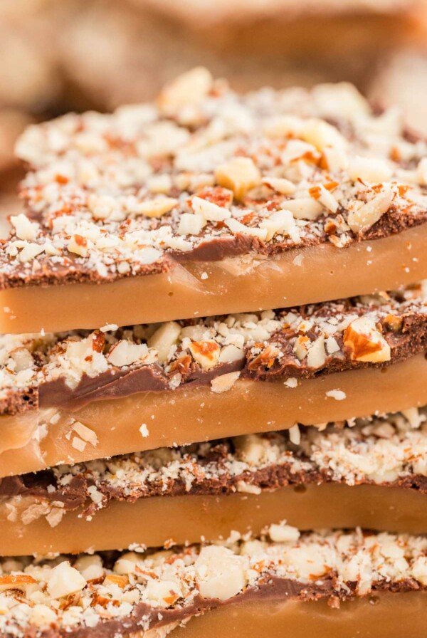 A stack of old fashioned toffee candies topped with toasted almonds.