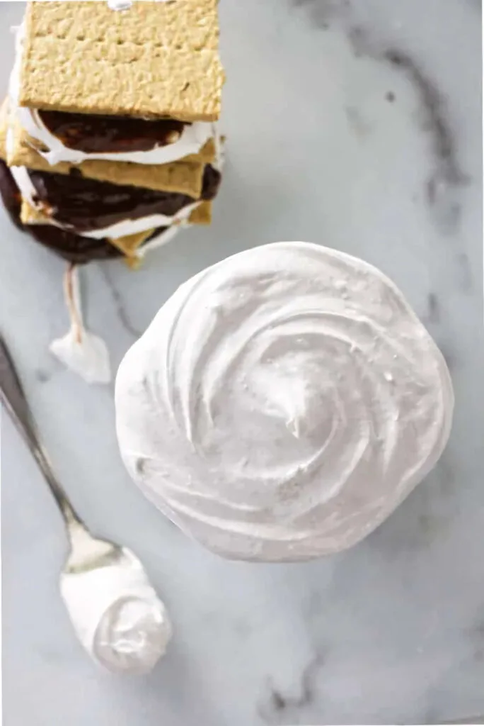 An overhead photo of marshmallow cream next to graham crackers.