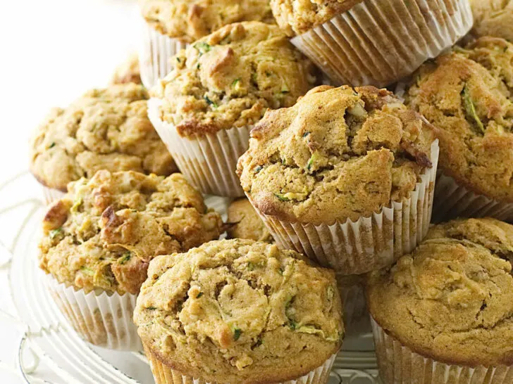 A stack of kamut zucchini muffins on a white cooling rack.