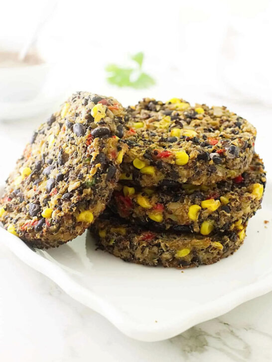 A stack of quinoa and black bean burger patties on a white plate.