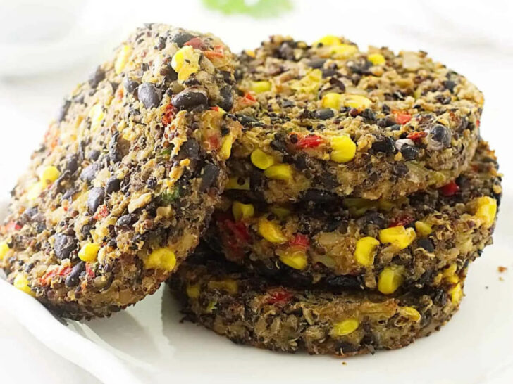 A stack of quinoa and black bean burger patties on a white plate.