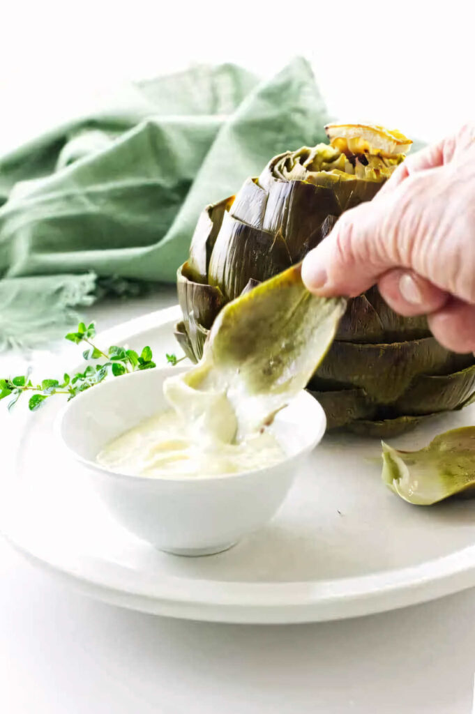 Dipping an artichoke leaf into aioli.