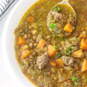 A bowl filled with a serving of sausage lentil soup.