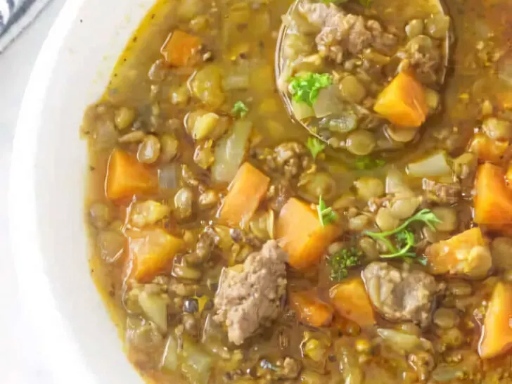 A bowl filled with a serving of sausage lentil soup.