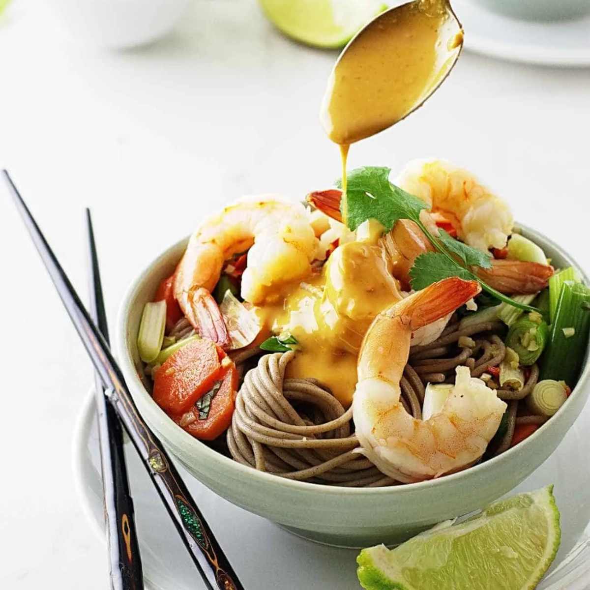 Soba noodles and shrimp in a bowl with veggies and peanut sauce.