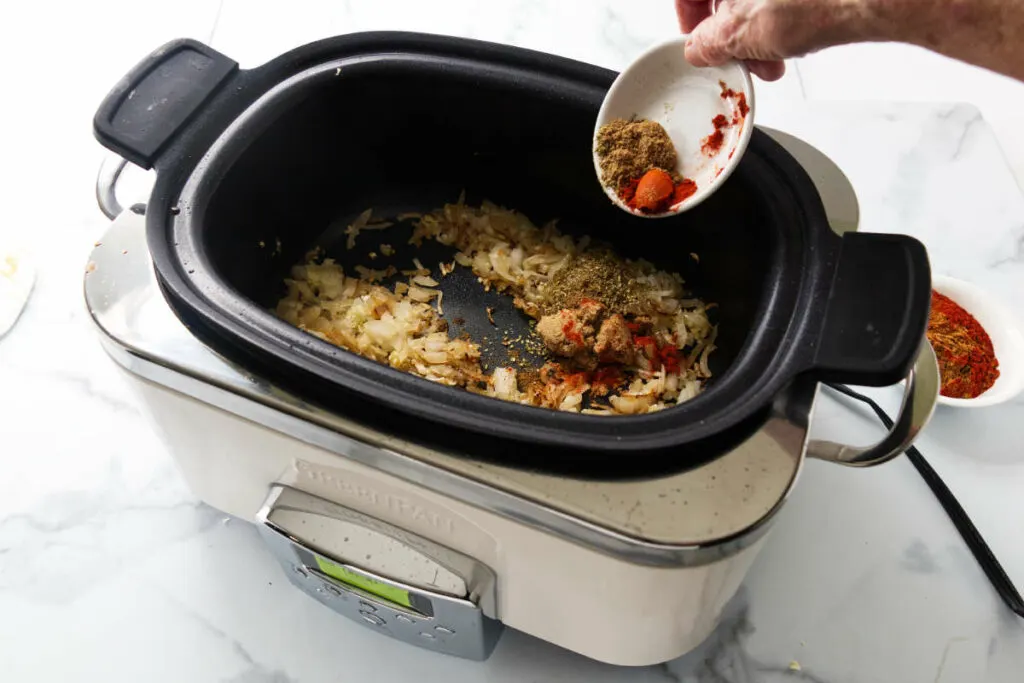 Placing the spices in the slow cooker.