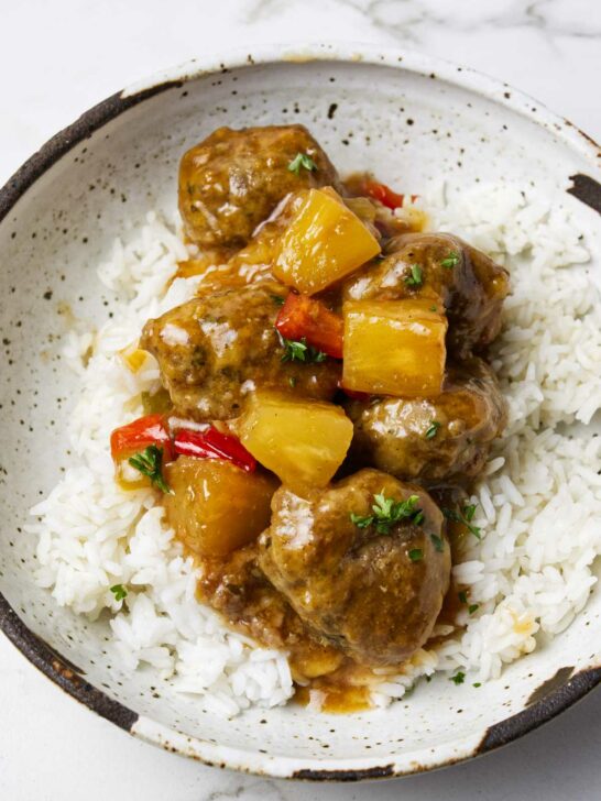 Sweet and sour meatballs on a pile of rice.