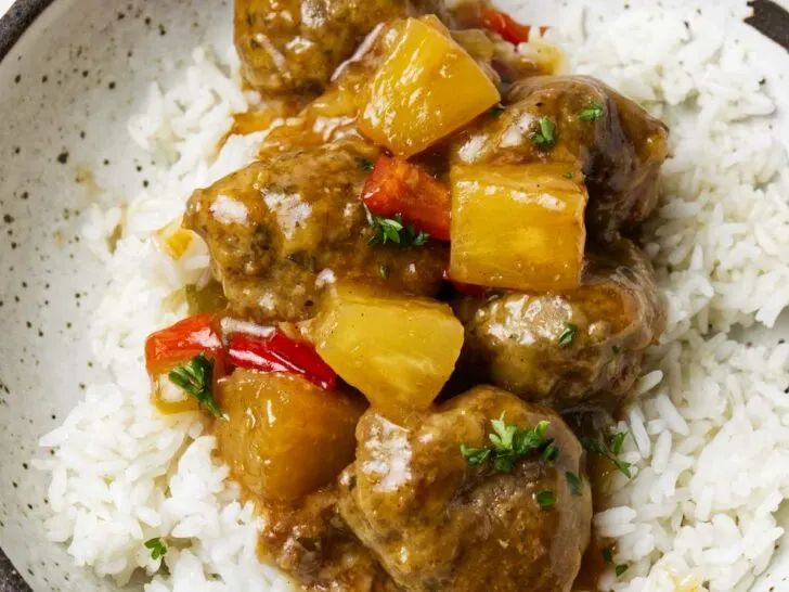 Sweet and sour meatballs on a pile of rice.