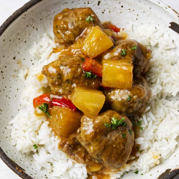 Sweet and sour meatballs on a pile of rice.