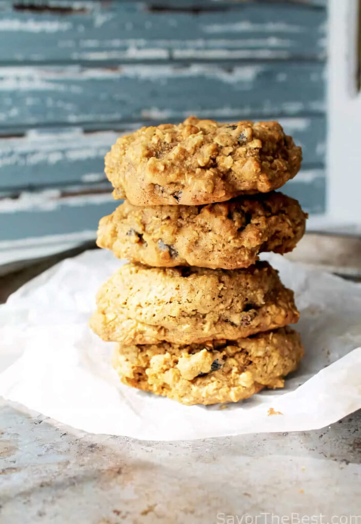 A stack of spelt oatmeal cookies on a piece of parchment paper.