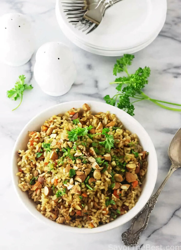 A sprouted brown rice pilaf in a serving bowl next to a phone.