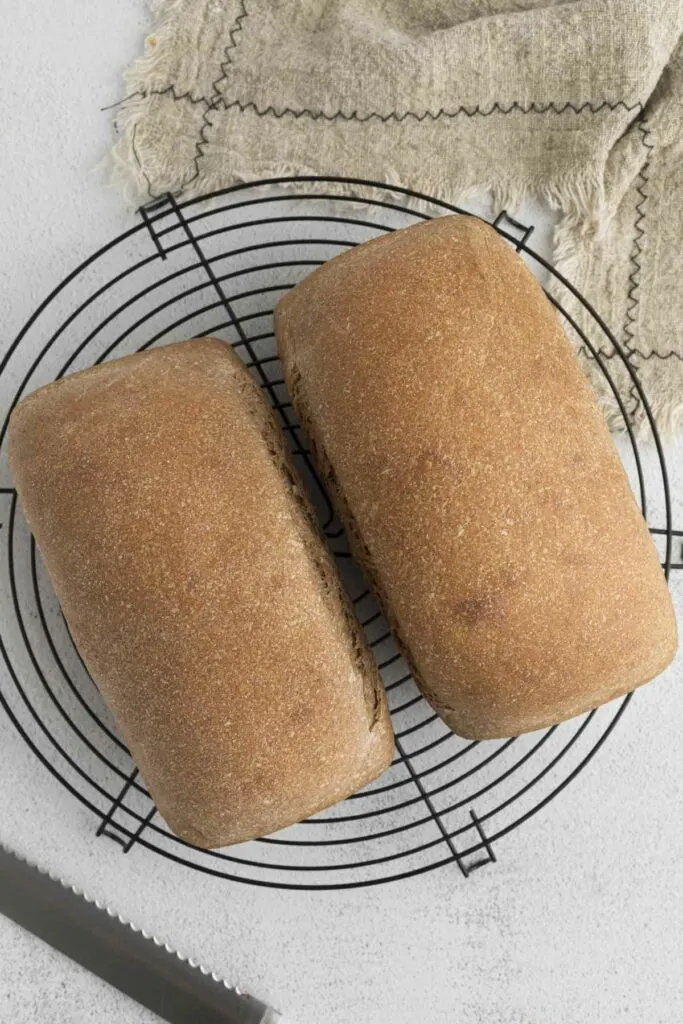 Cooling two loaves of sprouted wheat bread on a wire rack.