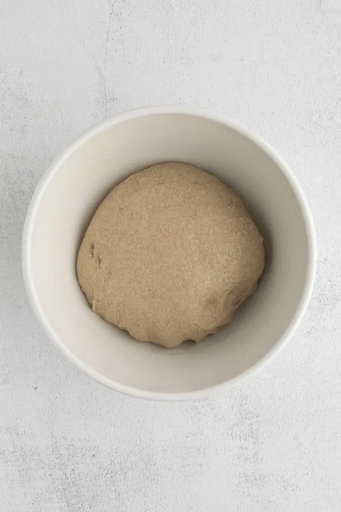 Placing dough in a bowl to do a bulk proof.