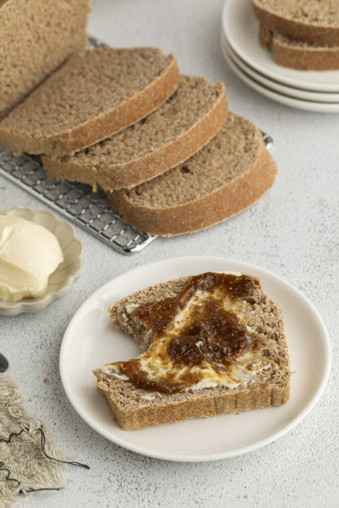 Several slices of sprouted wheat bread net to a partially eaten slice.