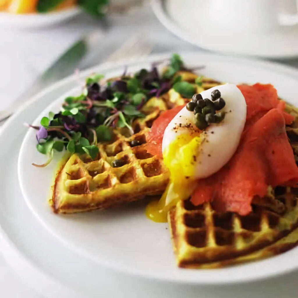 Poached egg and smoked salmon on top of a sweet potato waffle.