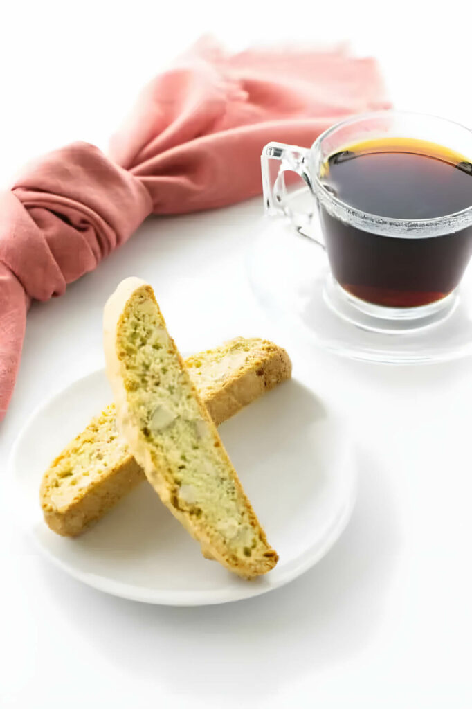 Two biscotti cookies next to a cup of coffee.