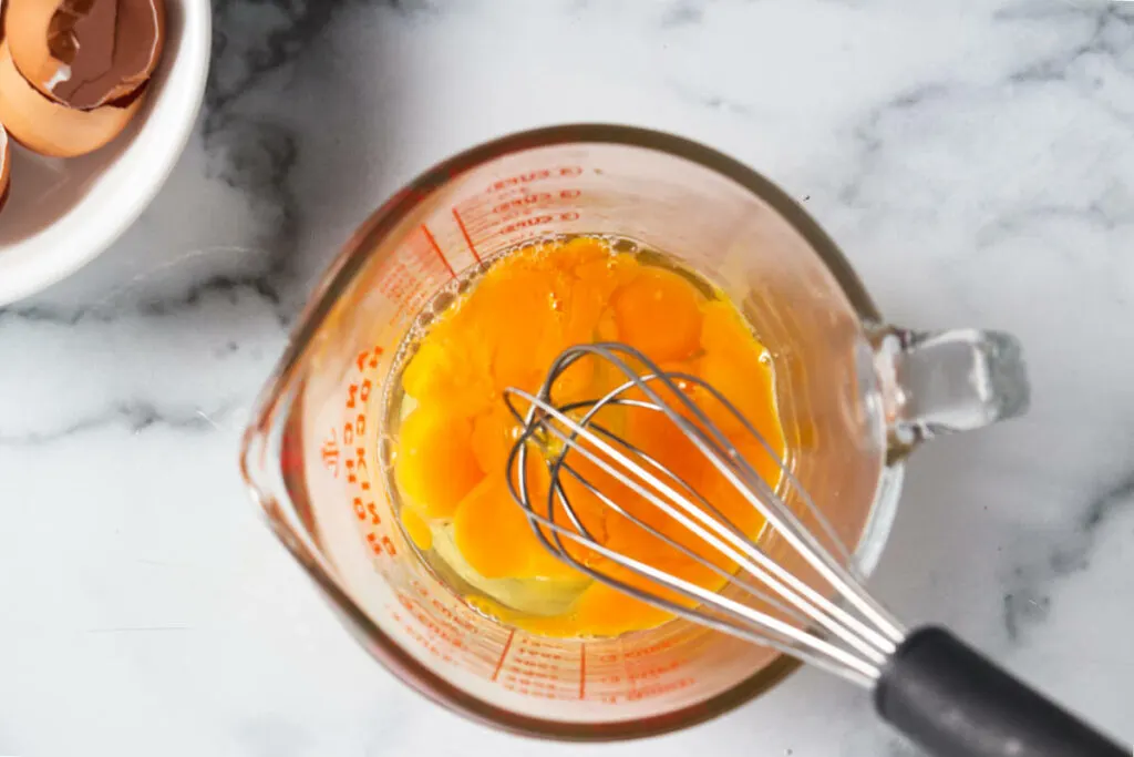 Whisking eggs in a dish.