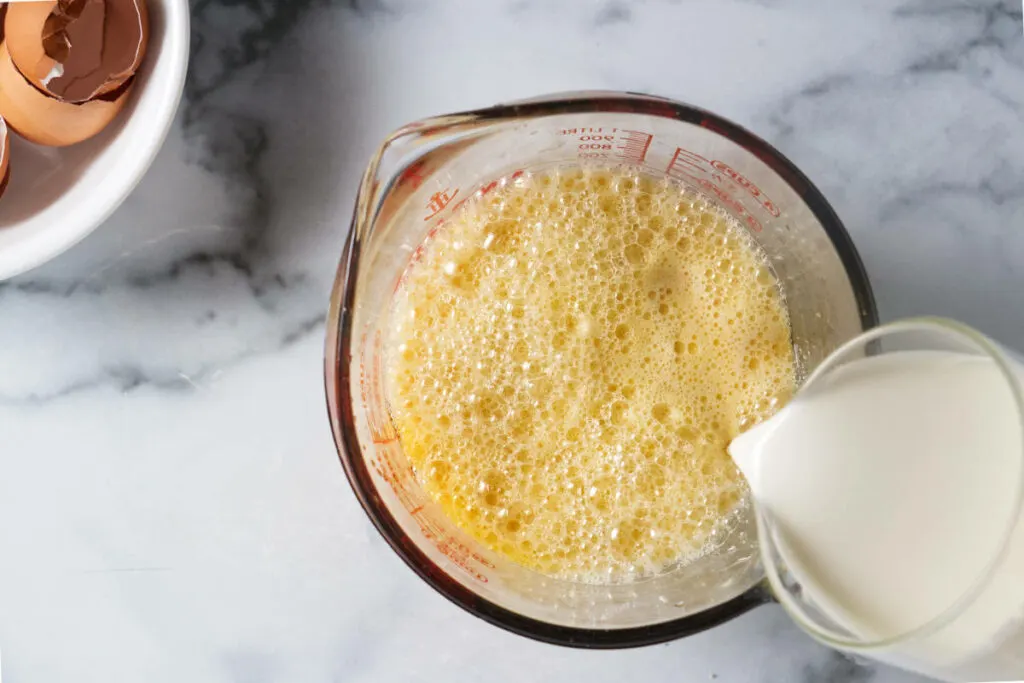 Adding cream to the custard mixture.