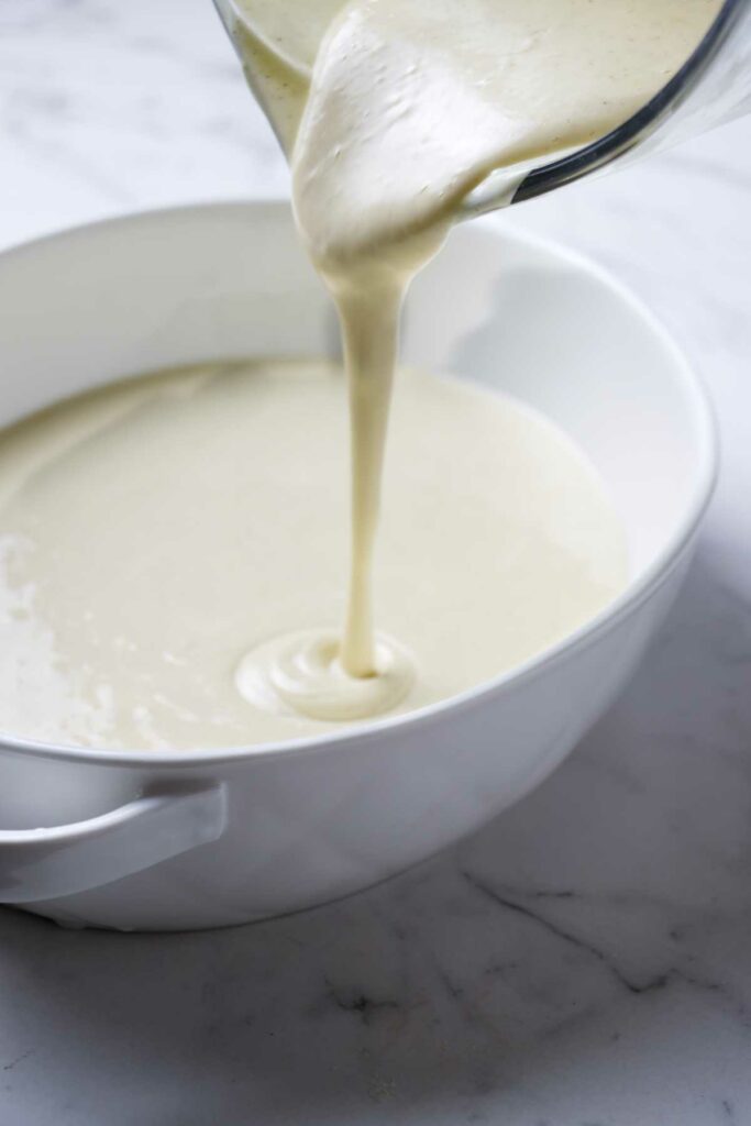 Pouring yogurt custard mixture into a baking dish.