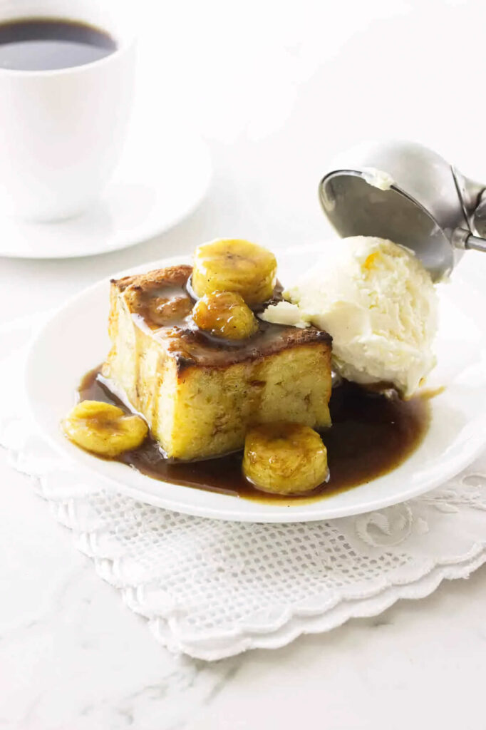 Adding a scoop of ice cream to a serving of banana bread pudding.