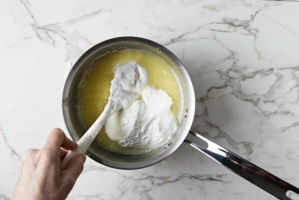 Stirring marshmallow cream into fudge mixture.