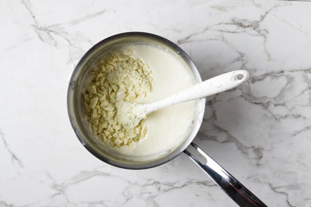 Stirring chopped white chocolate into the candy mixture.