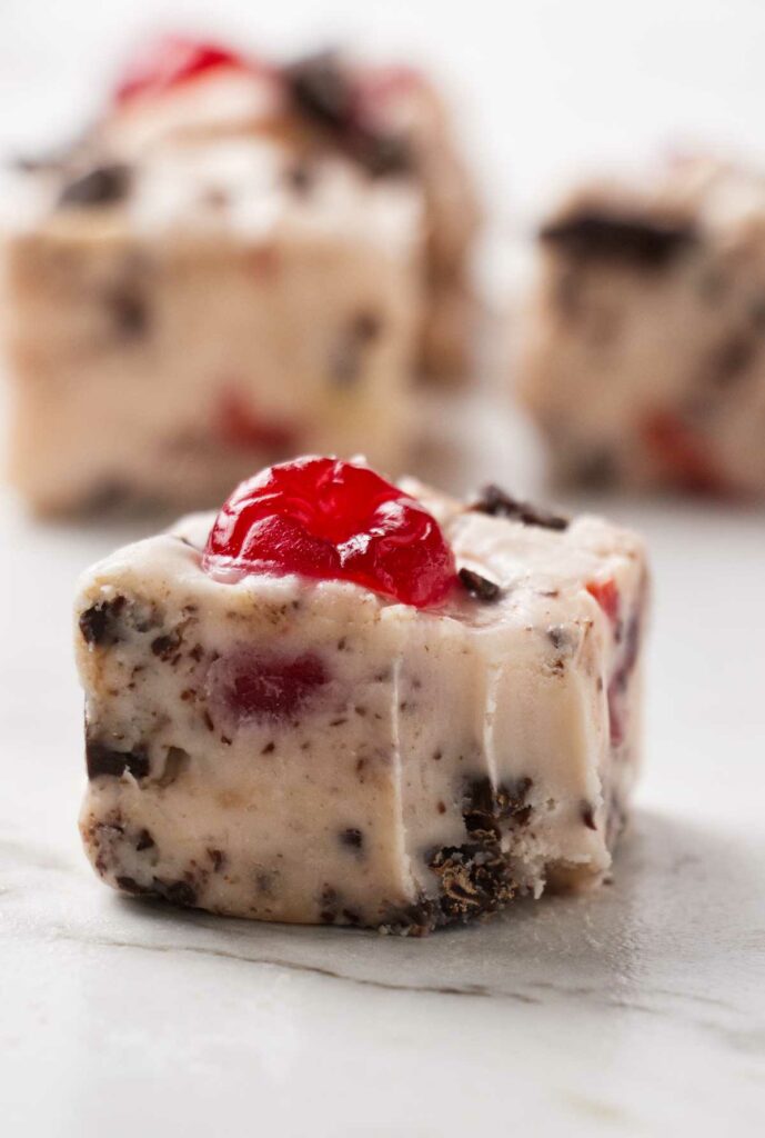 A square of cherry garcia fudge with several more slices in the background.