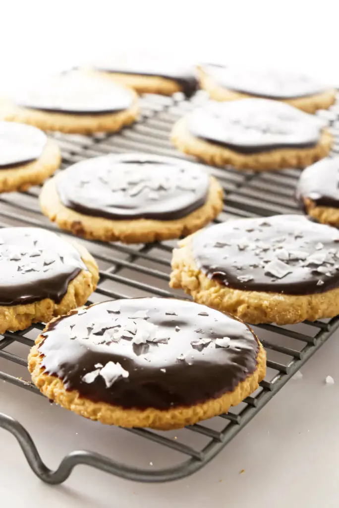 Several peanut butter cookies with chocolate icing on a wire rack.