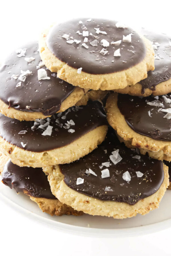 A plate filled with a stack of peanut butter cookies topped with chocolate icing.