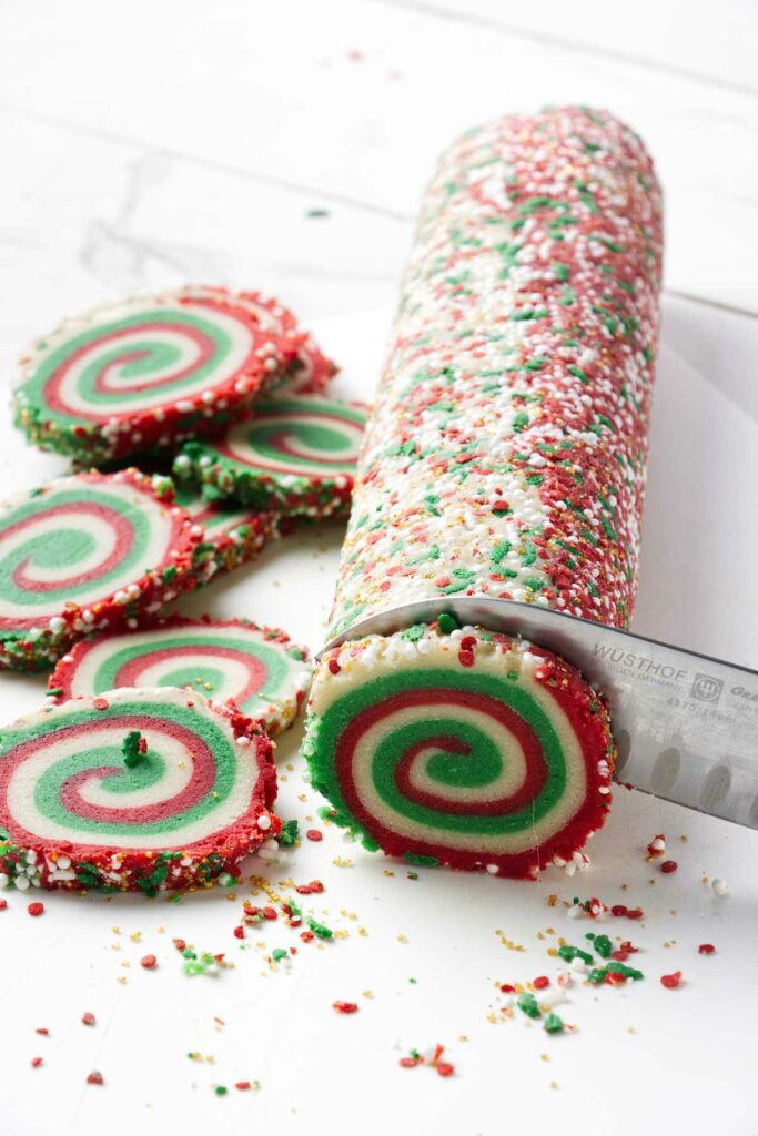 Slicing a log of cookie dough into individual cookies.