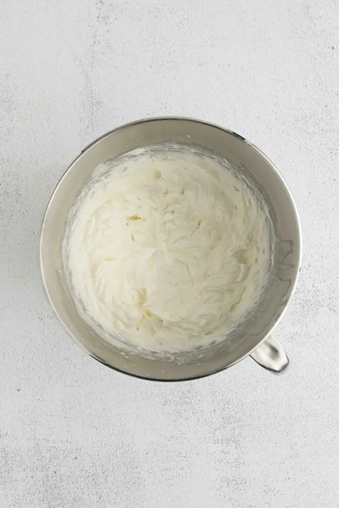 Mixing the cream cheese filling in a mixing bowl.