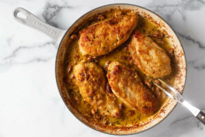 Nestling four chicken breasts into the creamy tomato sauce.
