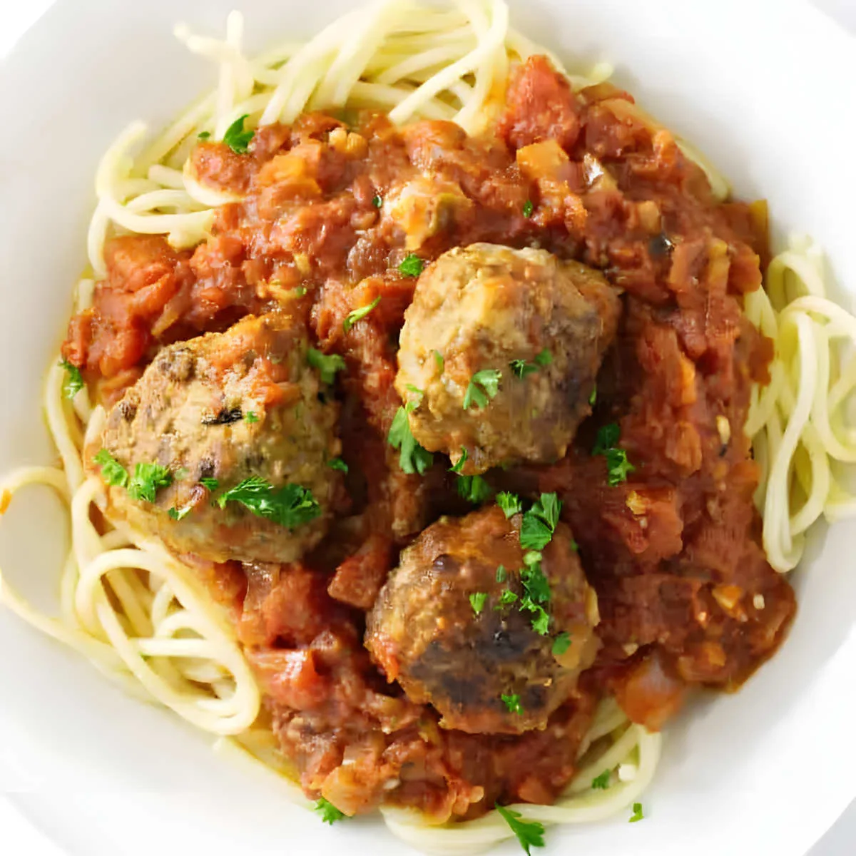 A pasta bowl filled with meatball sauce and spaghetti.