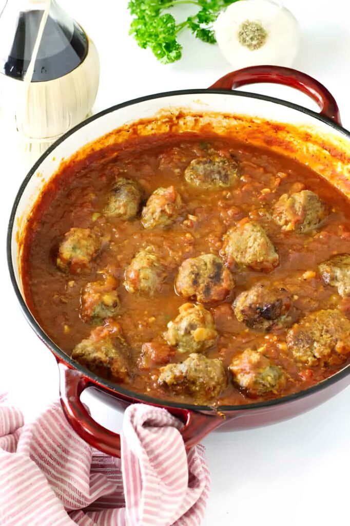 A pan with tomato garlic sauce and meatballs.