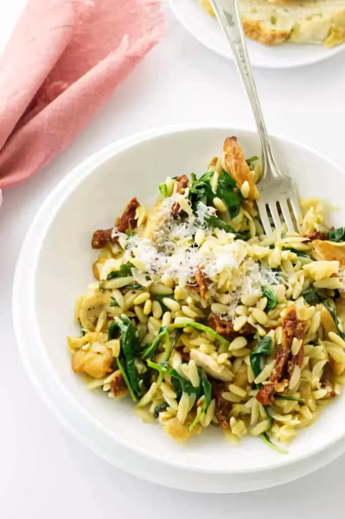 Chicken and orzo with kale in a bowl.