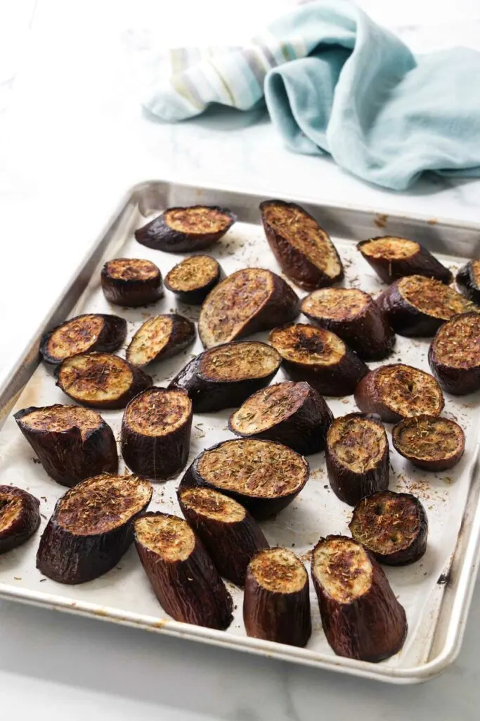 Roasted eggplant slices on a baking sheet.