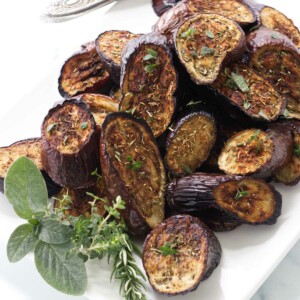 Eggplant roasted with herbs on a serving platter.