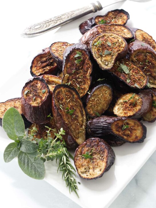 Eggplant roasted with herbs on a serving platter.