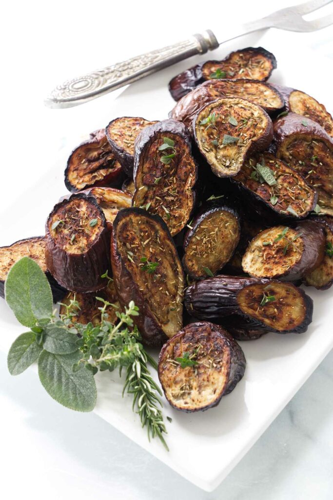 Eggplant roasted with herbs on a serving platter.