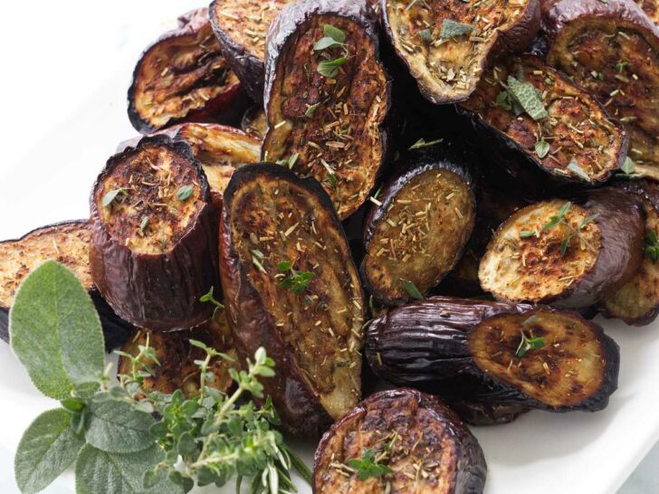 Eggplant roasted with herbs on a serving platter.