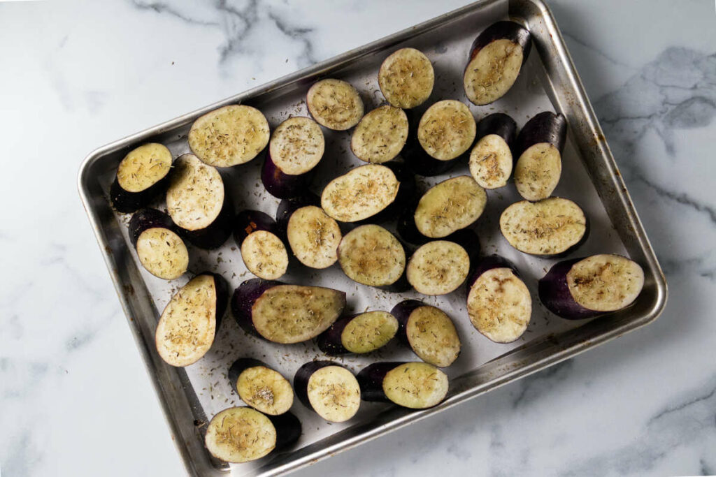 Eggplant slices on a sheet pan ready for the oven.